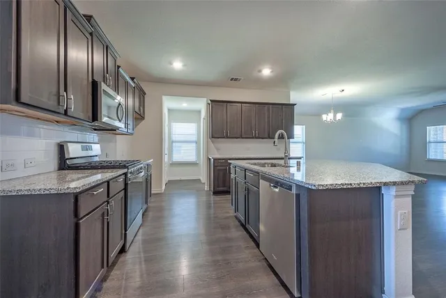 a kitchen with stainless steel appliances granite countertop wooden cabinets a sink and dishwasher