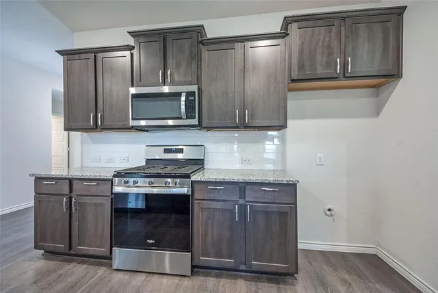 a kitchen with granite countertop wooden cabinets and stainless steel appliances