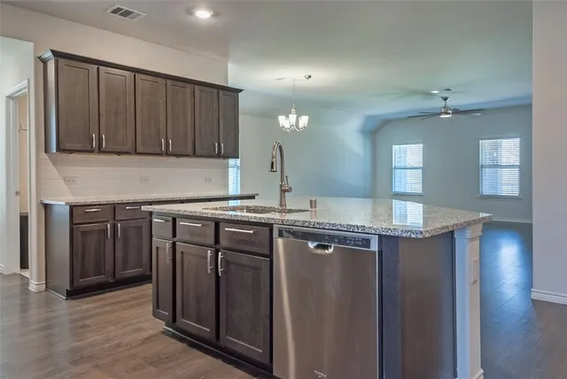 a kitchen with stainless steel appliances granite countertop a sink a stove and a refrigerator