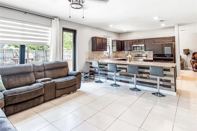a living room with furniture a flat screen tv and large window