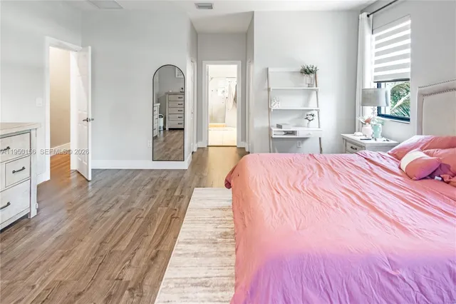 a bedroom with a bed and wooden floor
