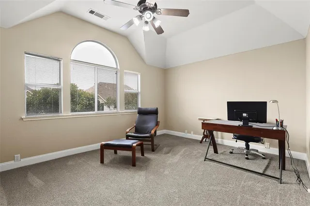 a view of a workspace with furniture and a window