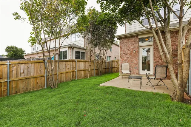 a view of a backyard with table and chairs and a large tree