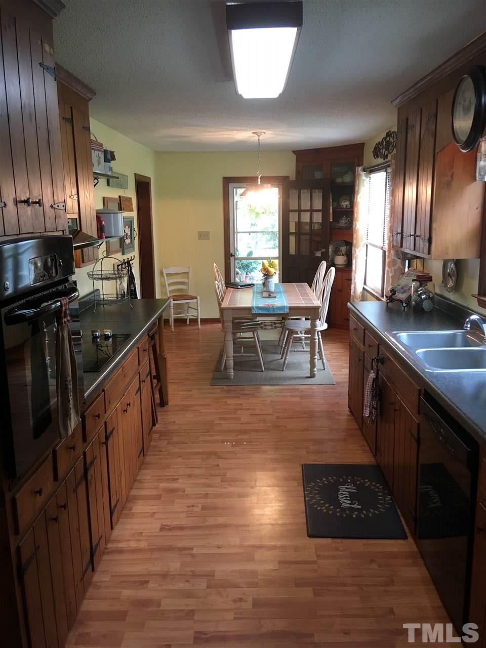 518 Pilot-Riley Road Zebulon, NC 27597 - Photo 11 of 25 a kitchen with stainless steel appliances granite countertop sink stove top oven and cabinets
