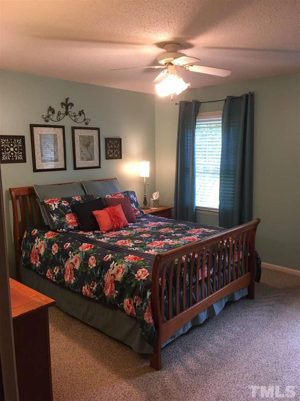 518 Pilot-Riley Road Zebulon, NC 27597 - Photo 20 of 25 a bedroom with a large bed and a chandelier