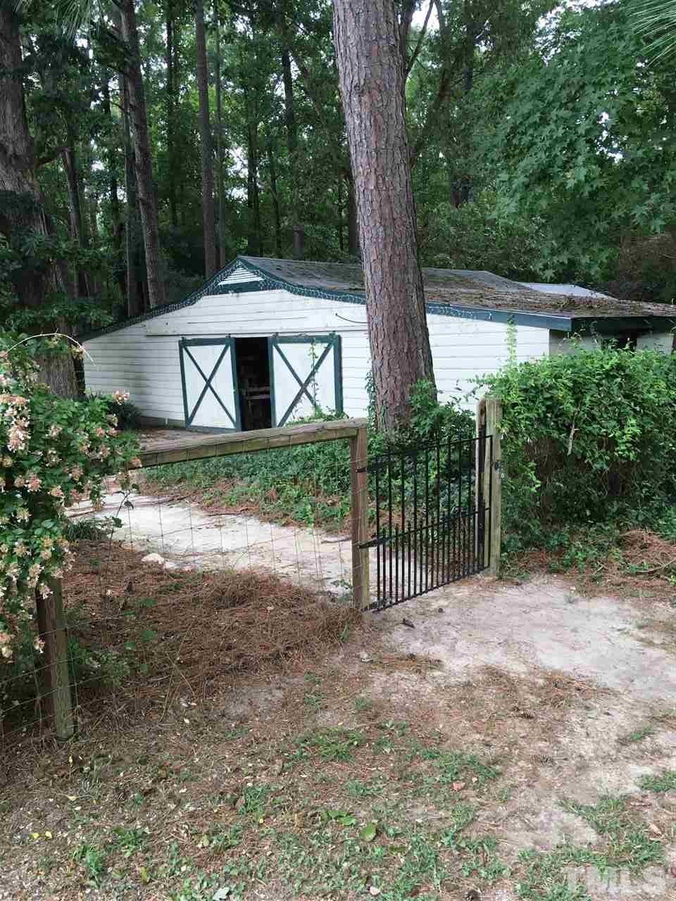 518 Pilot-Riley Road Zebulon, NC 27597 - Photo 8 of 25 a backyard of a house with large trees and plants