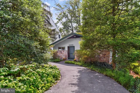 a view of a house with a tree and flower plants