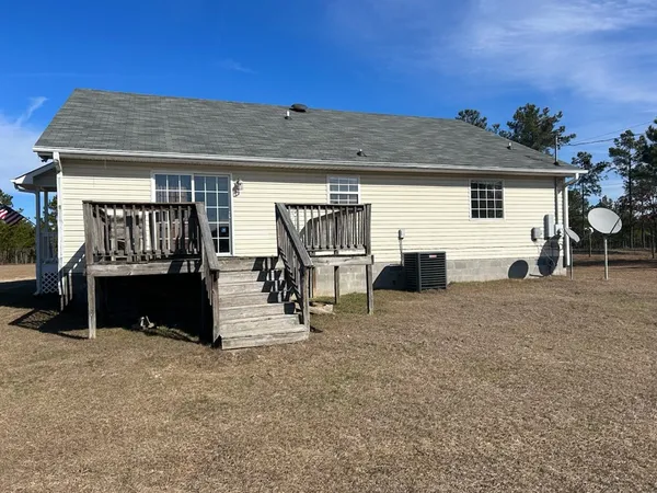 a view of a house with backyard and a car