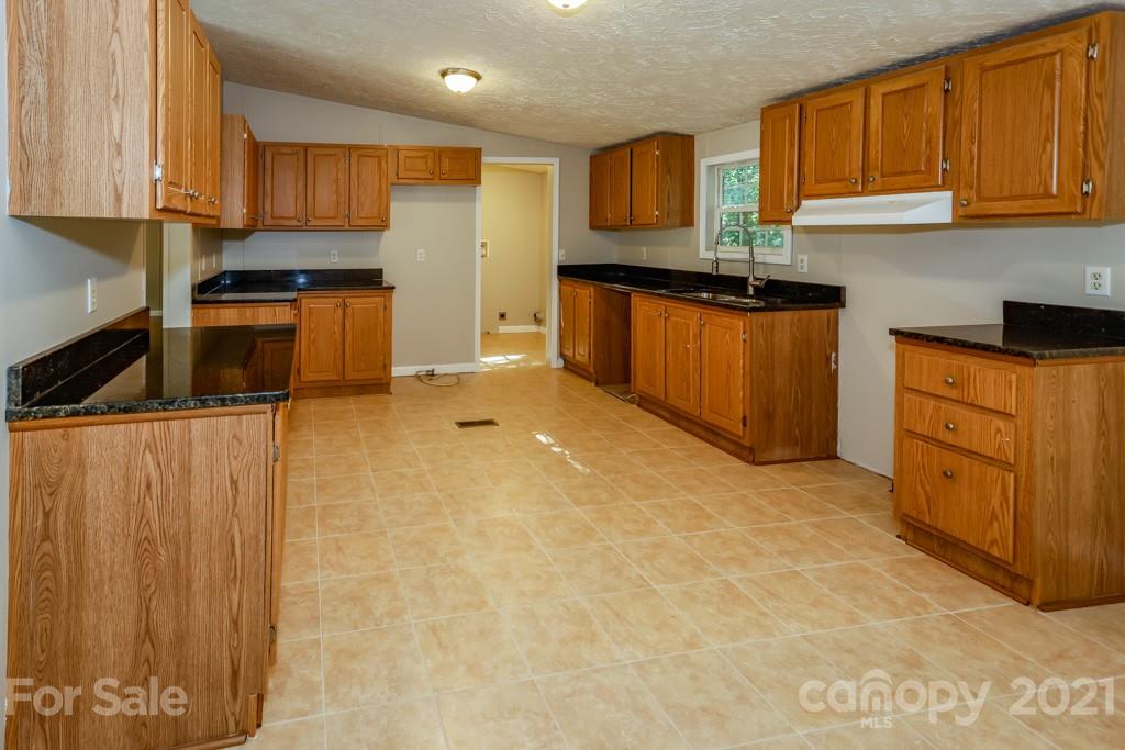 525 Hamilton Road Rutherfordton, NC 28139 - Photo 12 of 39 a kitchen with granite countertop a sink stove and cabinets