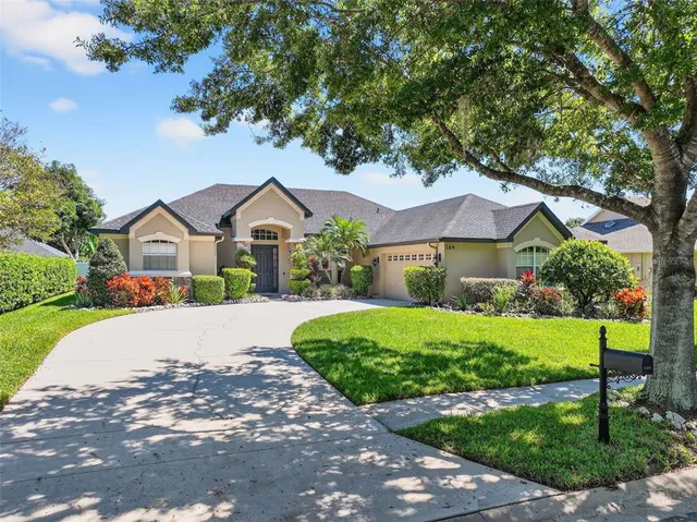 a front view of a house with a yard and green space