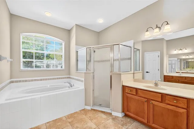 a living room with stainless steel appliances a dining table wooden floor and a large window