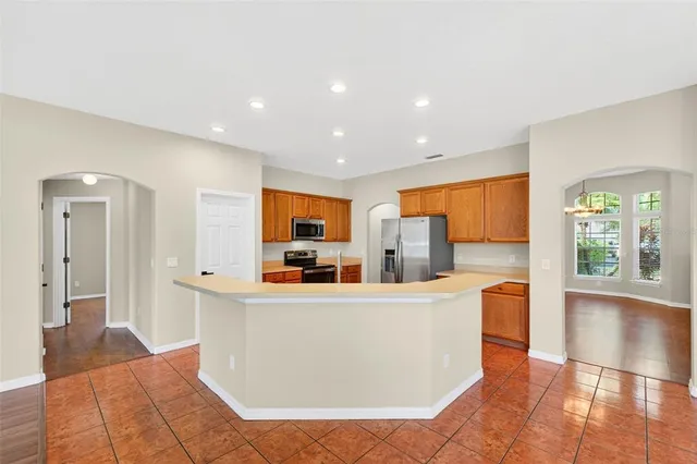 a kitchen with stainless steel appliances granite countertop a sink and a refrigerator