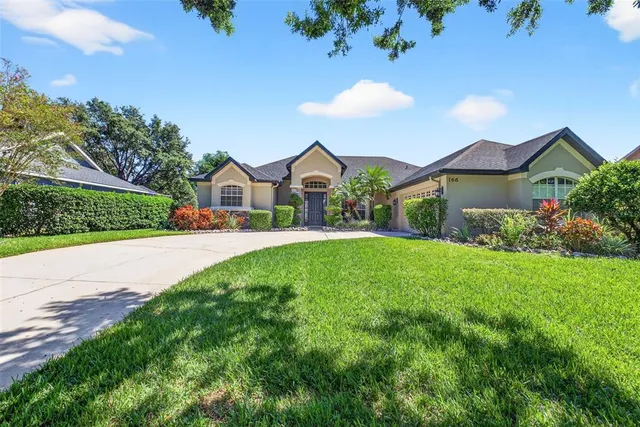 a view of house and garden with large trees