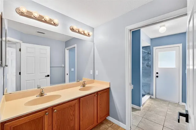 a bathroom with a double vanity sink and a mirror