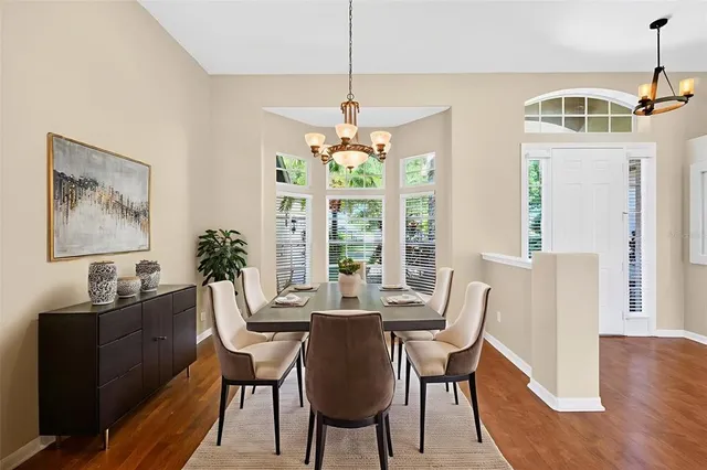 a dining room with furniture a chandelier and wooden floor