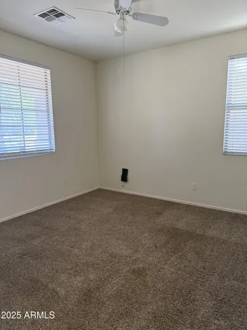 an empty room with a window and a ceiling fan