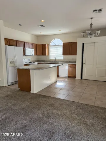 a living room with stainless steel appliances kitchen island granite countertop a sink and cabinets
