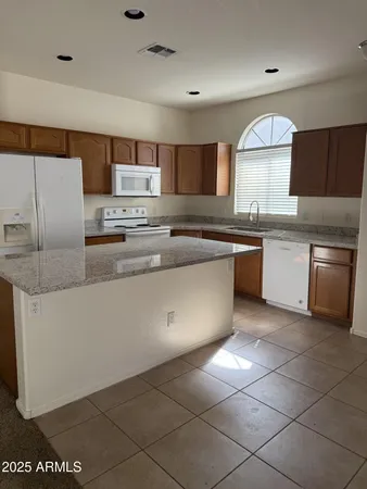 a kitchen with stainless steel appliances granite countertop a sink counter space cabinets and a large window