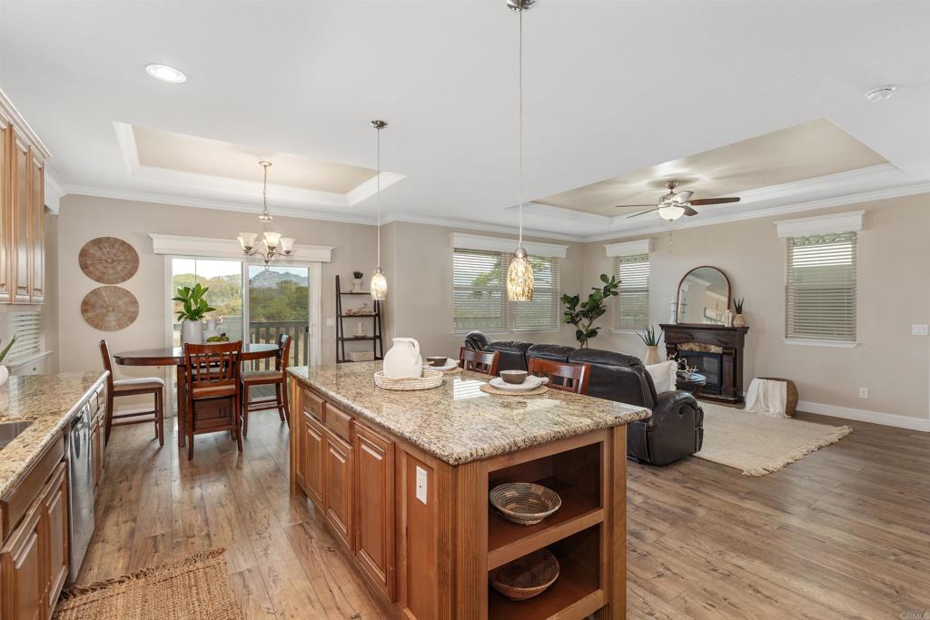 9500 Harritt Road, Unit 29 Lakeside, CA 92040 - Photo 16 of 32 a kitchen with granite countertop a stove a sink a dining table and chairs with wooden floor