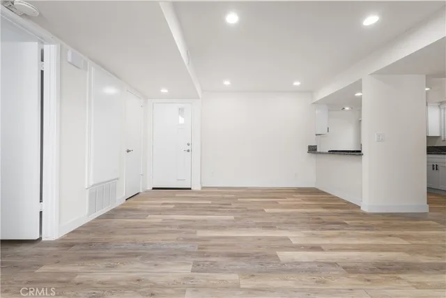a view of an empty room with wooden floor