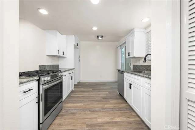 a kitchen with granite countertop a sink and a stove top oven