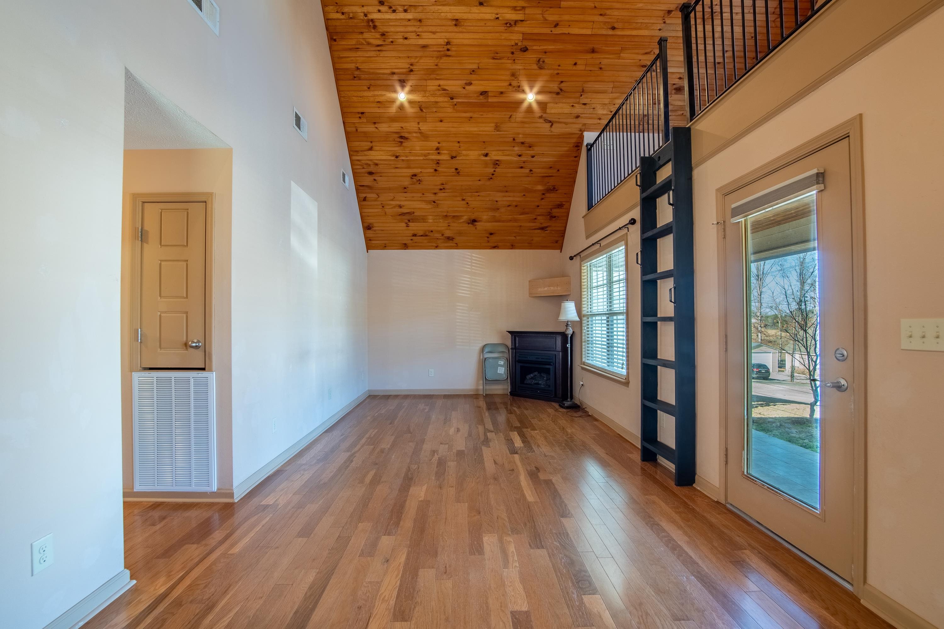 20 Bogey Loop Counce, TN 38326 - Photo 8 of 39 Unfurnished living room featuring wood ceiling, light hardwood / wood-style flooring, and high vaulted ceiling