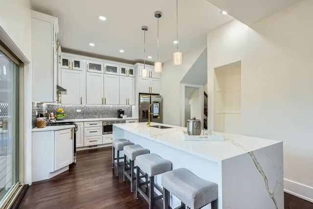 a kitchen with a sink a stove a refrigerator and white cabinets with wooden floor