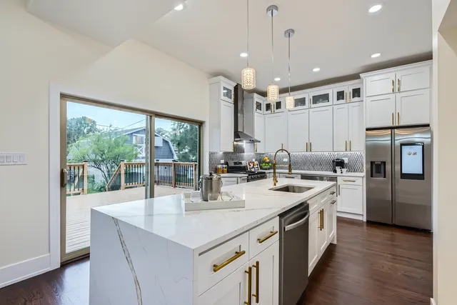 a kitchen with stainless steel appliances granite countertop a sink a stove and a refrigerator