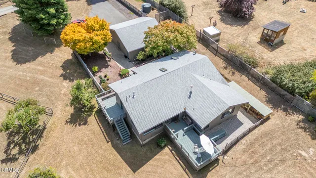 an aerial view of a house with swimming pool and sitting area