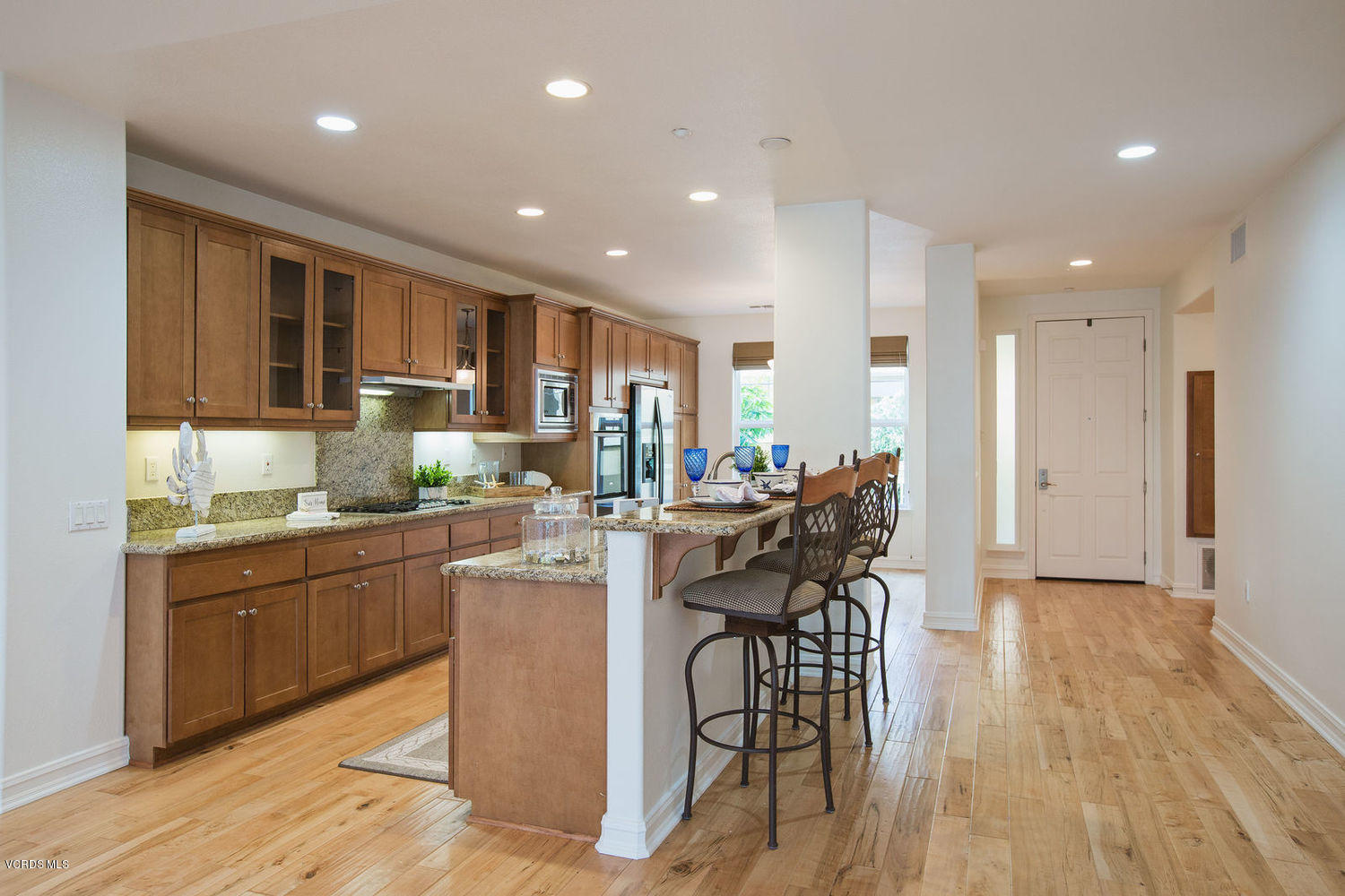1533 Windshore Way Oxnard, CA 93035 - Photo 11 of 28 a kitchen with stainless steel appliances granite countertop wooden floor dining table and chairs