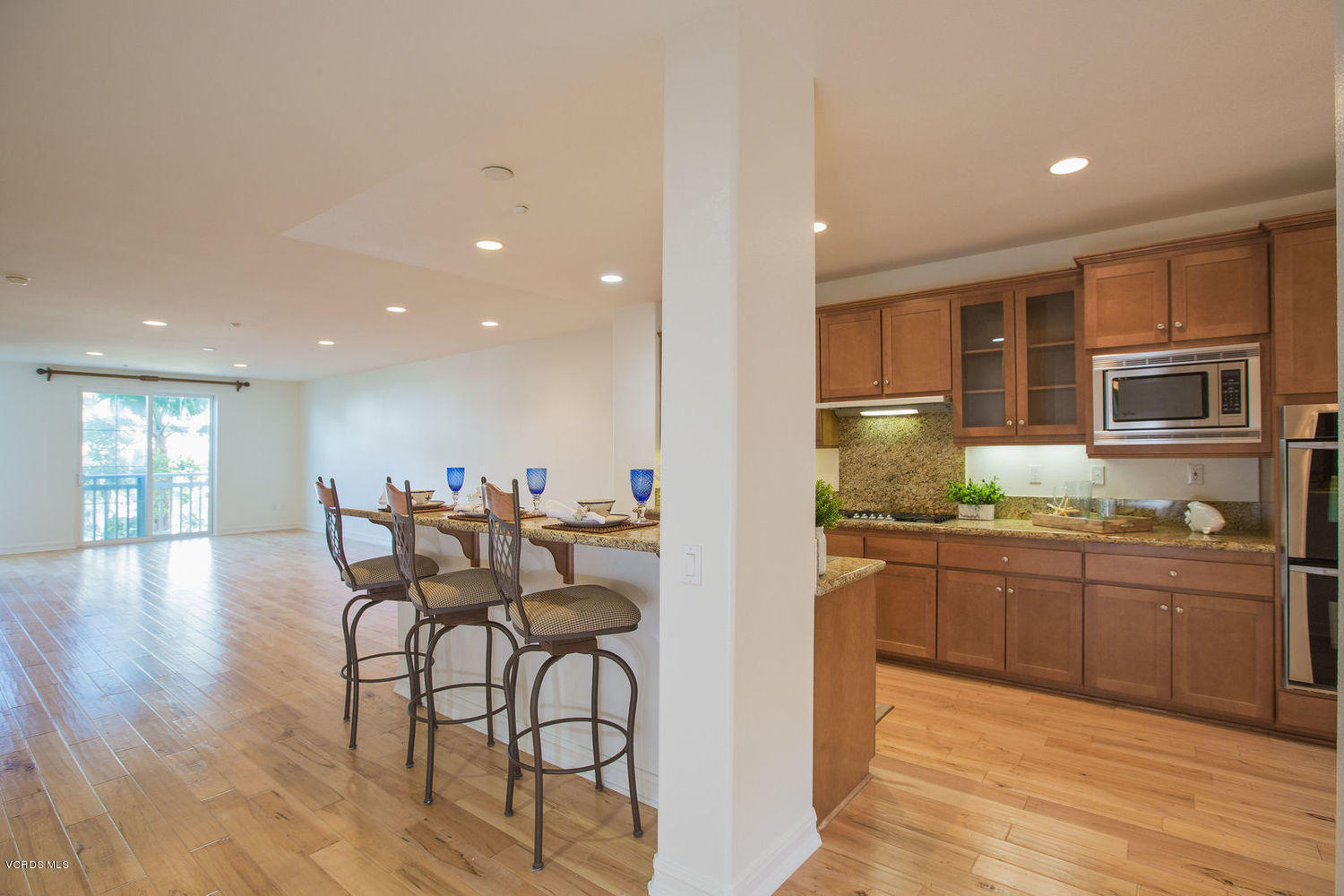 1533 Windshore Way Oxnard, CA 93035 - Photo 8 of 28 a kitchen with stainless steel appliances granite countertop a stove top oven a sink dishwasher a dining table and chairs with wooden floor