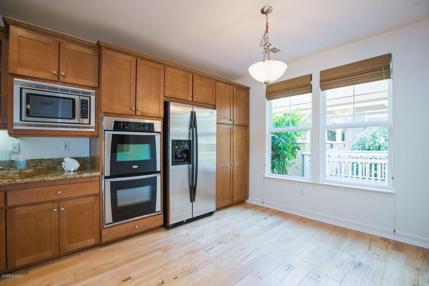 1533 Windshore Way Oxnard, CA 93035 - Photo 10 of 28 a kitchen with stainless steel appliances granite countertop a refrigerator a stove a microwave and wooden floors