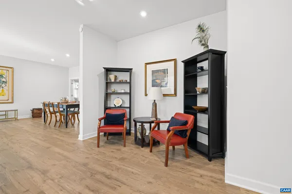 a living room with furniture floor to ceiling window hardwood floor and a flat screen tv