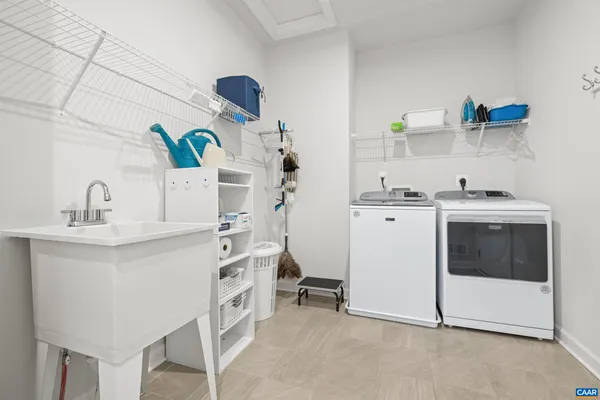 a view of a white house with a big yard and potted plants