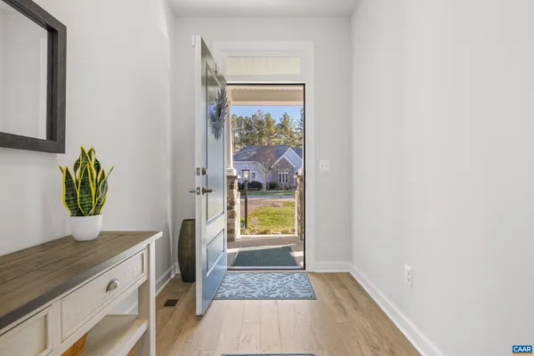 a view of hallway with wooden floor and a potted plant