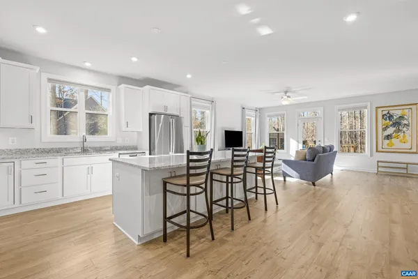a kitchen with stainless steel appliances white cabinets and wooden floor