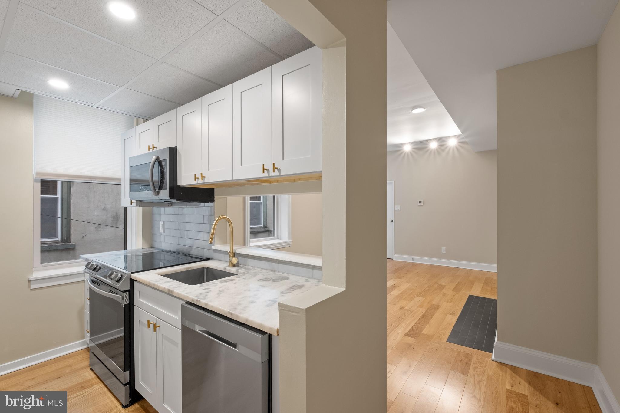 a kitchen with a sink a microwave a refrigerator and cabinets