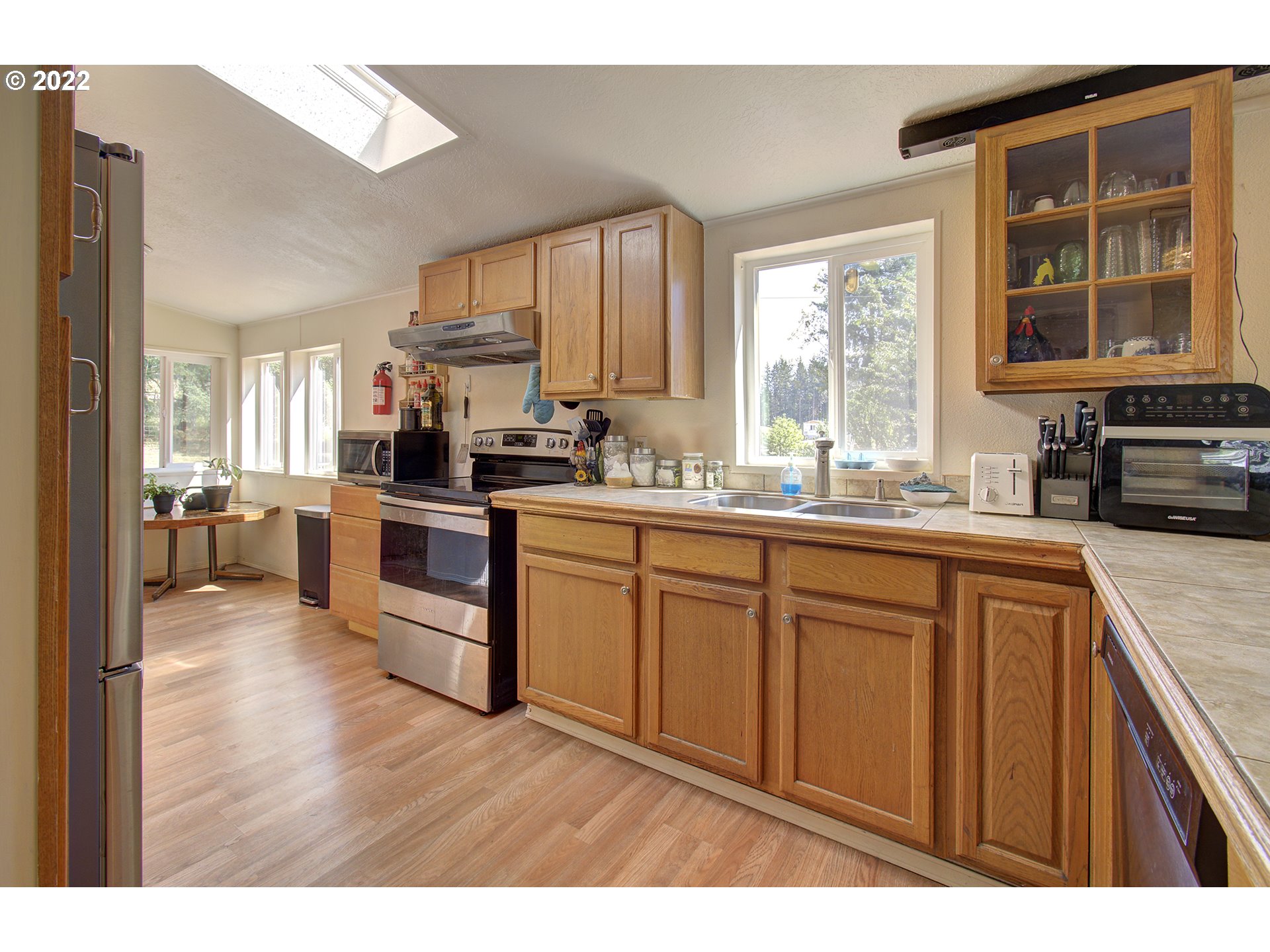 24416 Northeast Berry Road Battle Ground, WA 98604 - Photo 11 of 31 a kitchen with stainless steel appliances kitchen island granite countertop a sink dishwasher stove and cabinets