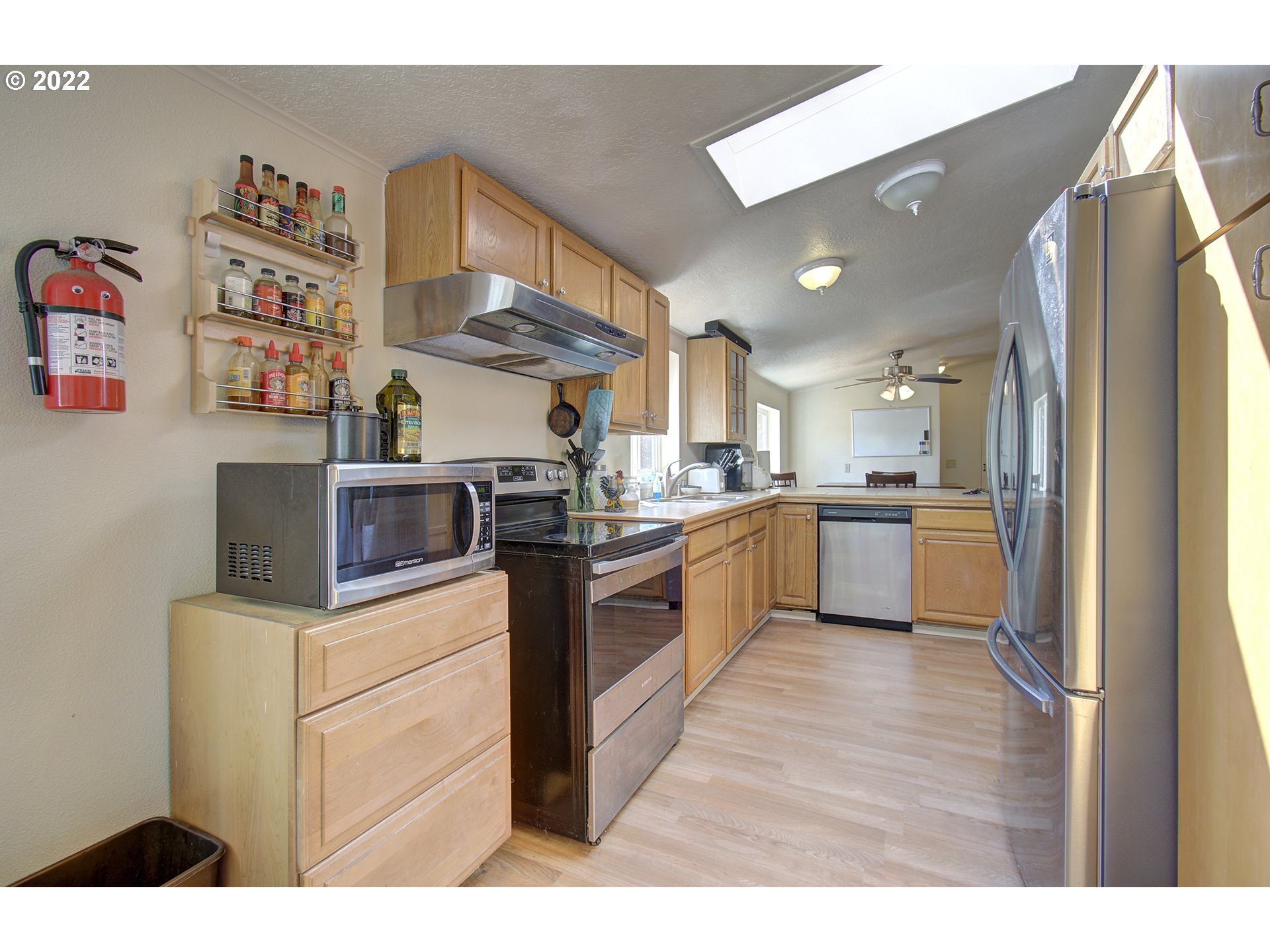 24416 Northeast Berry Road Battle Ground, WA 98604 - Photo 12 of 31 a kitchen with stainless steel appliances kitchen island a refrigerator sink and cabinets