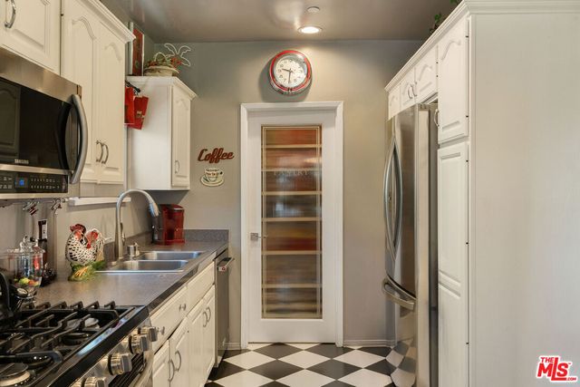 a kitchen with stainless steel appliances granite countertop a refrigerator and a stove top oven