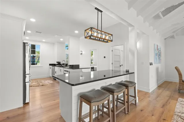 a kitchen with granite countertop stainless steel appliances a stove a sink and a refrigerator