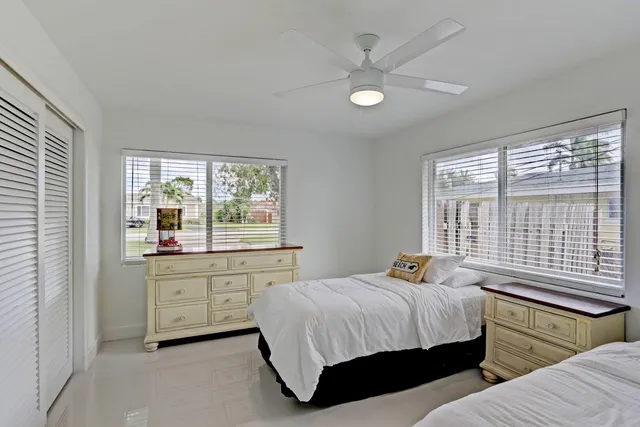 a bedroom with 2 bed and a window