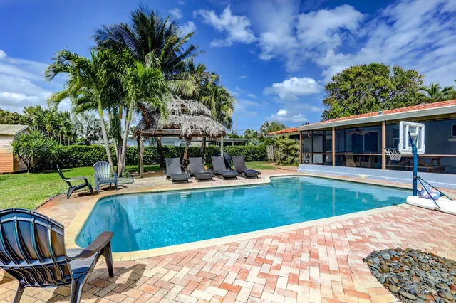 a view of a house with swimming pool and sitting area