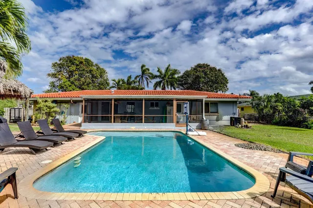 swimming pool view with a seating space and a garden