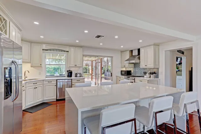 a kitchen with stainless steel appliances granite countertop a stove refrigerator and cabinets