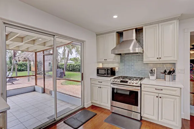 a kitchen with stainless steel appliances granite countertop a stove a refrigerator and white cabinets