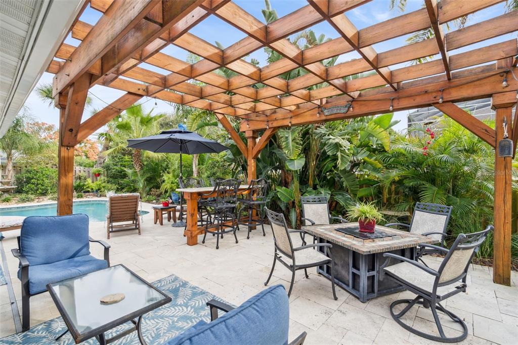 75 Calumet Avenue Ponce Inlet, FL 32127 - Photo 20 of 35 a view of a patio with a dining table and chairs under an umbrella with a small yard