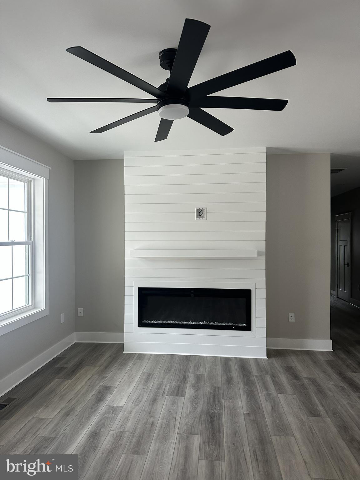 19426 Parsons Road Georgetown, DE 19947 - Photo 2 of 18 a view of an empty room with wooden floor fireplace and a window