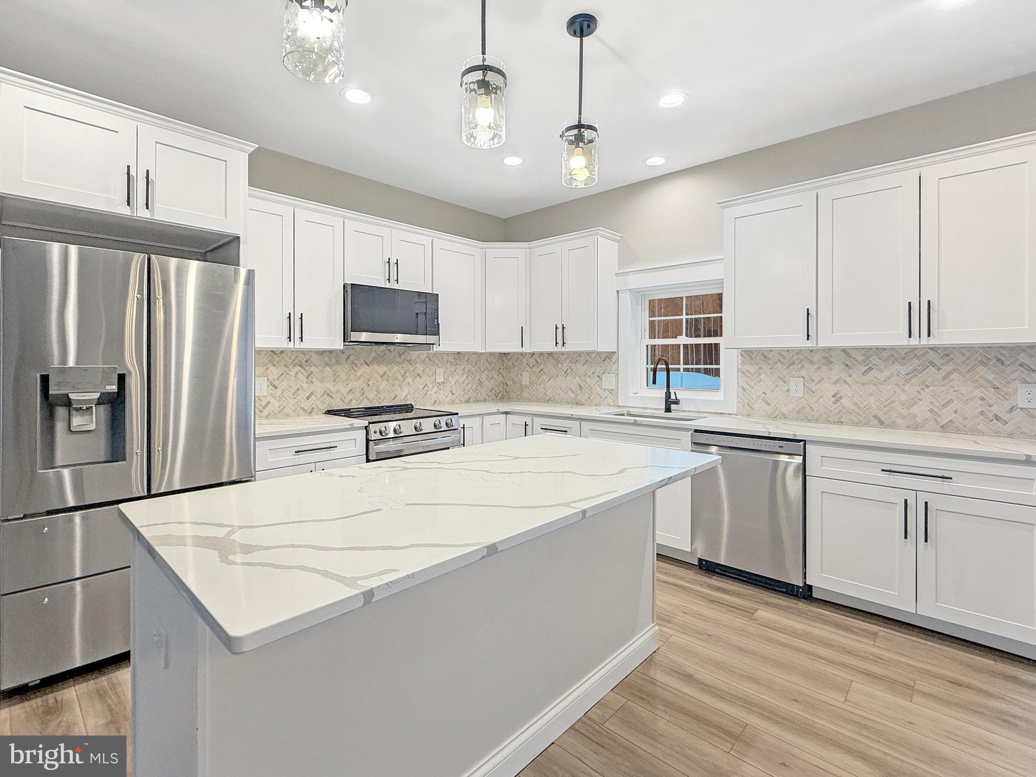 19426 Parsons Road Georgetown, DE 19947 - Photo 3 of 18 a kitchen with stainless steel appliances granite countertop a refrigerator a sink dishwasher a stove top oven a refrigerator and white cabinets