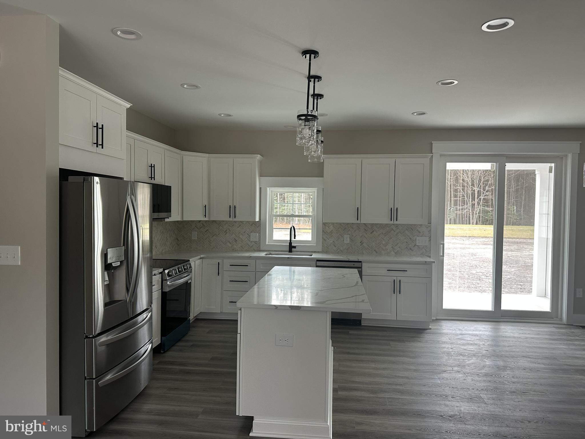19426 Parsons Road Georgetown, DE 19947 - Photo 5 of 18 a kitchen with stainless steel appliances granite countertop a refrigerator a sink dishwasher a stove and white countertops with wooden floor